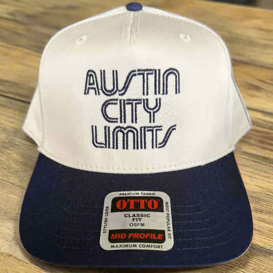 Two baseball caps with 'Austin City Limits' and 'Otto' branding on a dark surface.