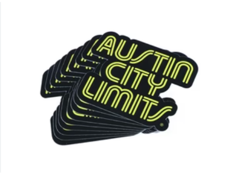 A stack of yellow and black diecut stickers with the text 'AUSTIN CITY LIMITS' on them.