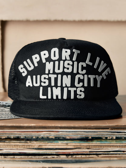 Black cap with 'Support Live Music Austin City Limits' text on a stack of records.