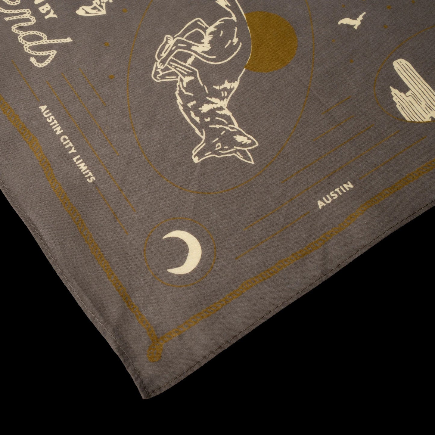 Gray bandana with gold and white designs and text on a black background