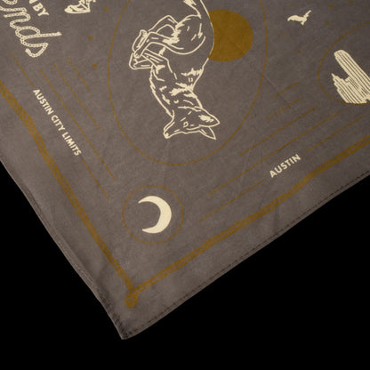 Gray bandana with gold and white designs and text on a black background
