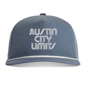 A slate blue snapback cap with 'AUSTIN CITY LIMITS' embroidered in white outline text on the front, featuring a white accent stripe along the edge of the brim.