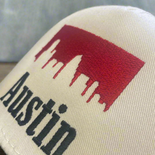 Beige pillow with red mountain silhouette and 'Austin' text
