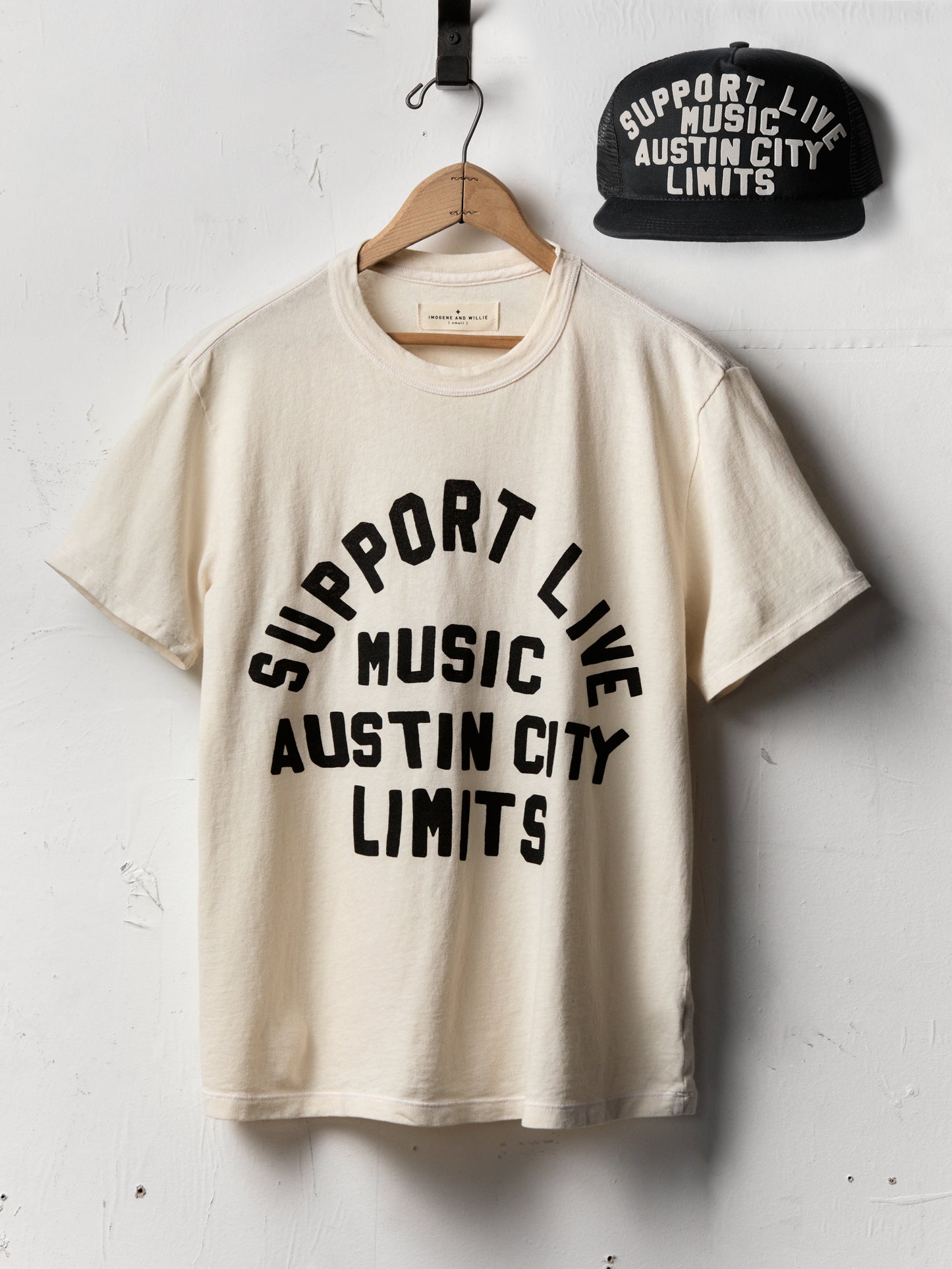 Beige t-shirt with 'Support Live Music Austin City Limits' text and a black cap on a white background