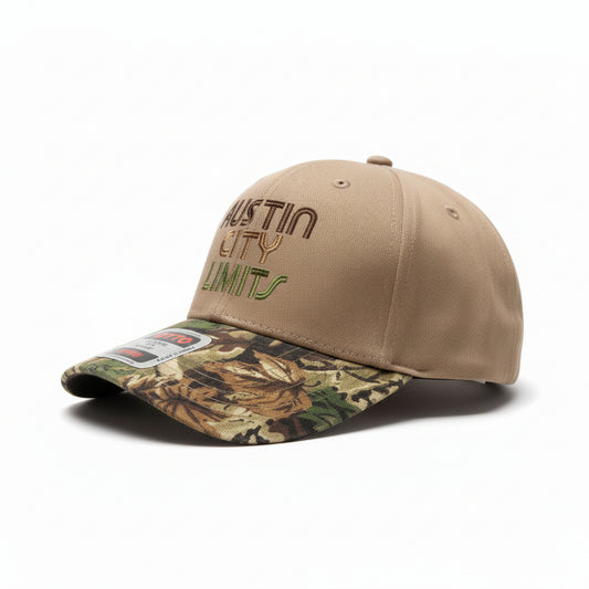 Two hats, one beige with 'Austin City Limits' text and one camouflage, on a wooden surface.