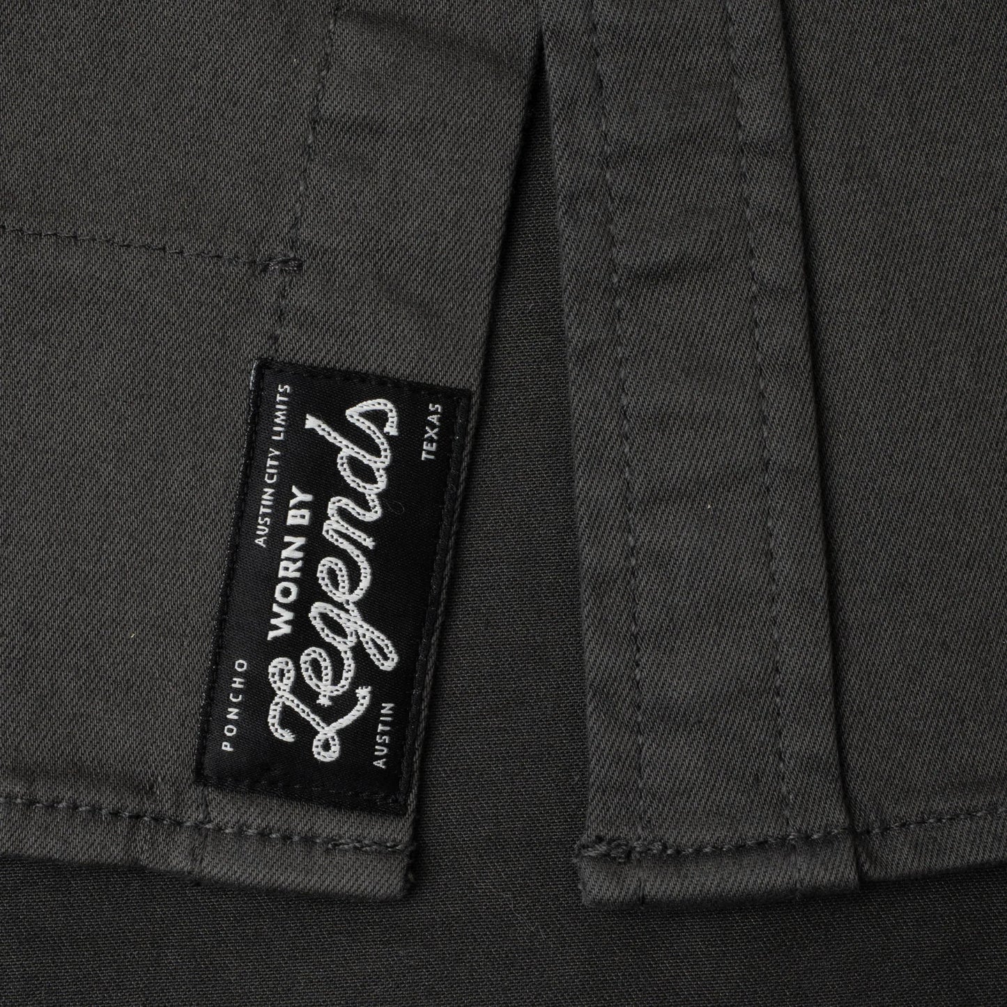 Close-up of a label on a dark fabric with 'Worn by Legends' branding.