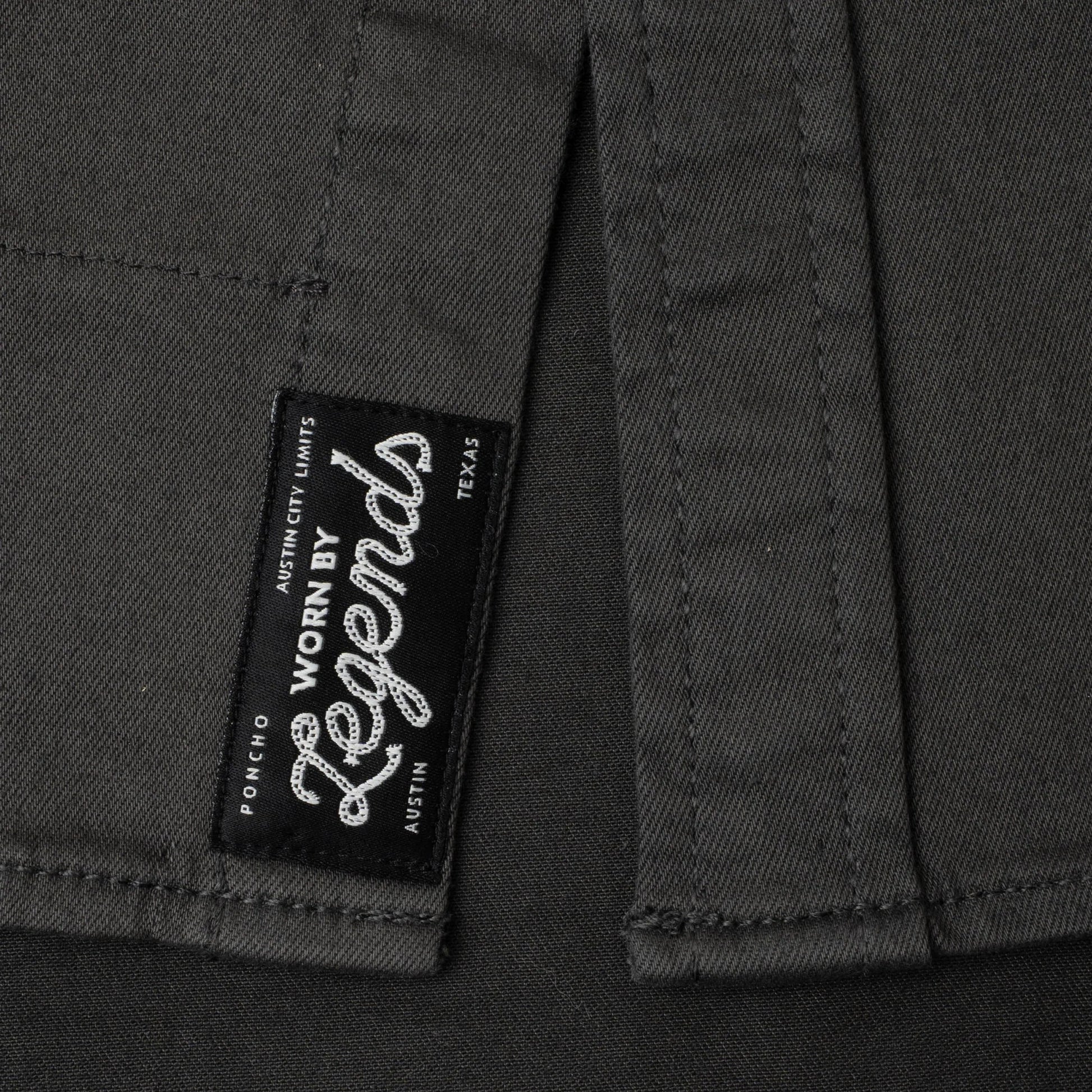 Close-up of a label on a dark fabric with 'Worn by Legends' branding.